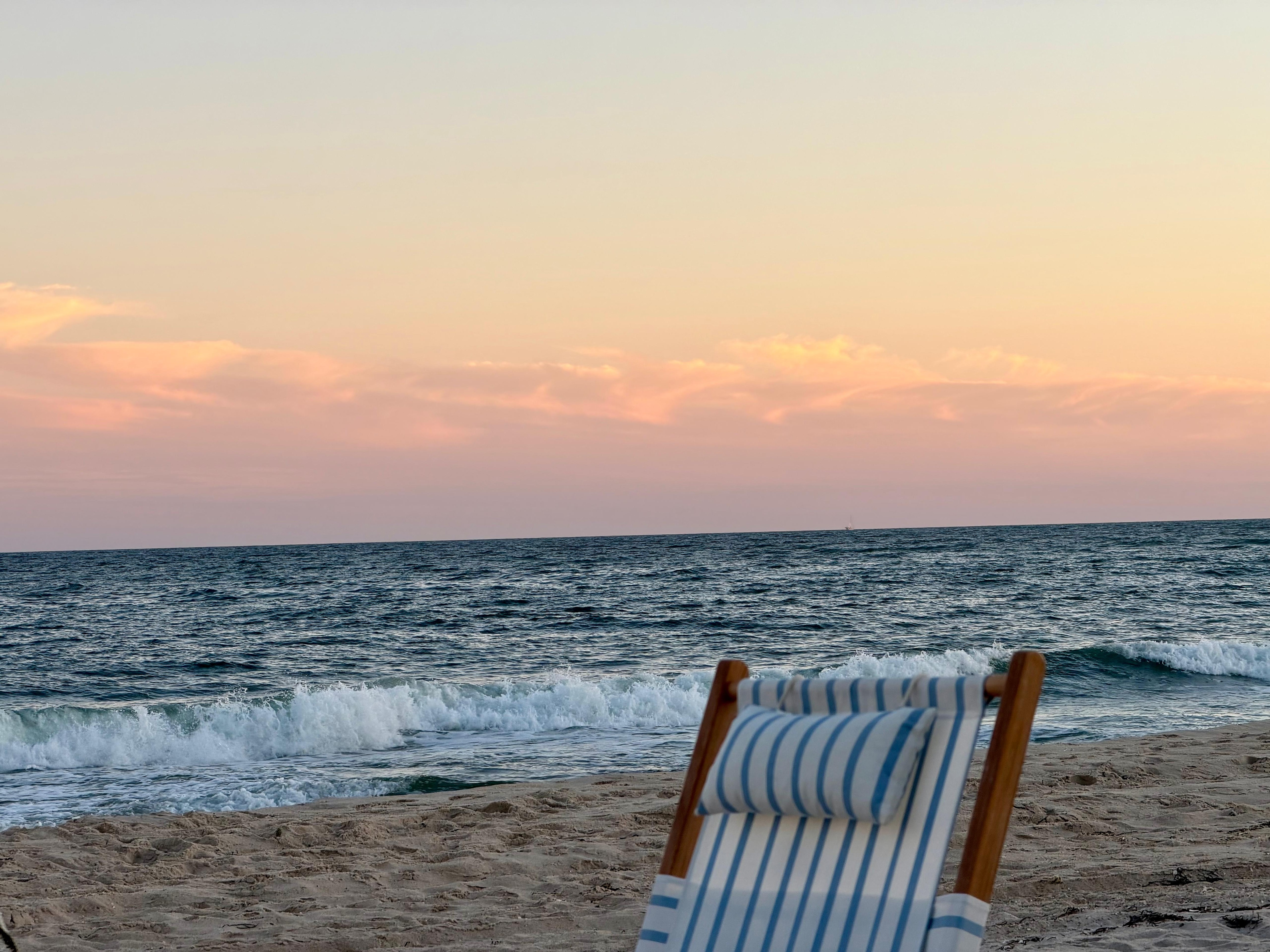 Beach chair facing the ocean at sunset in the Hamptons